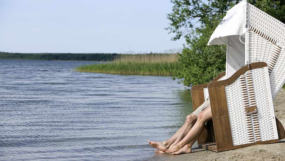 Strandkorb am Ufer des Fleesensees mit zwei Personen darin