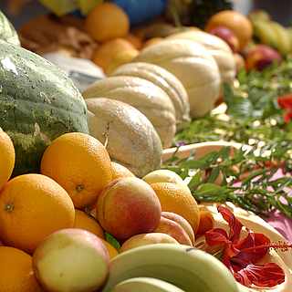 Frau hält einen Teller mit Müsli und Obst