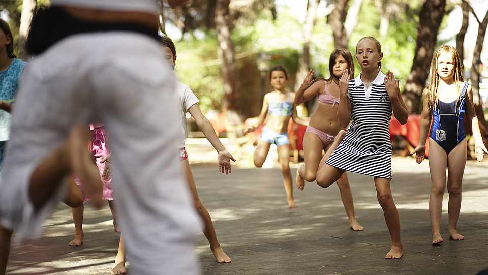 Kinder machen gemeinsam mit ihrem Betreuer Sport