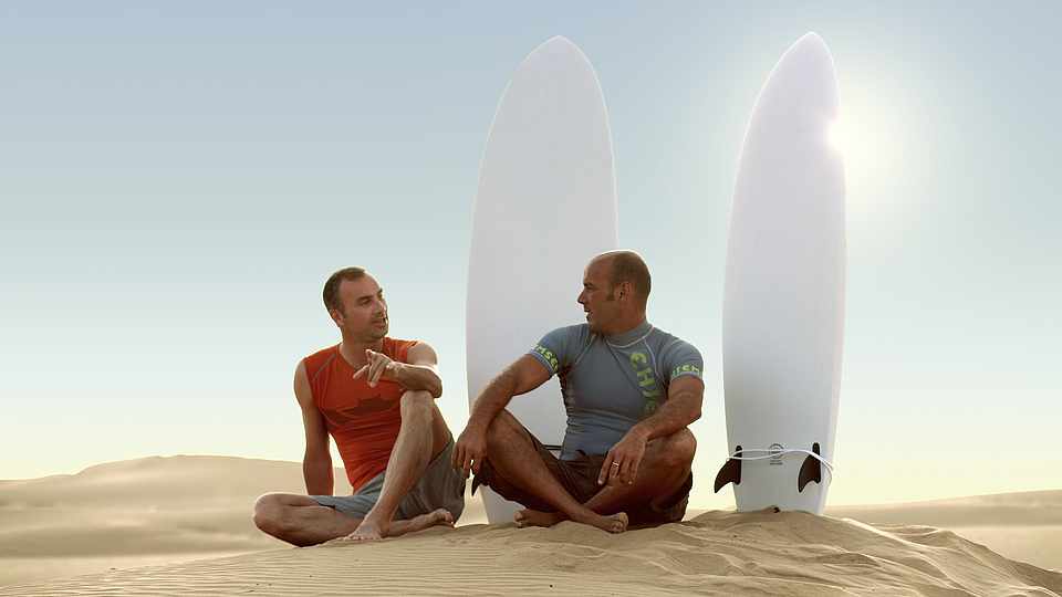 Zwei Männer mit Surfbrettern auf einer Düne im ROBINSON Club Agadir